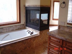 This is a beautiful tile-work tub and fireplace in a remodeled bathroom.