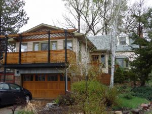 This is a view of a second story wood deck and pergola built above a garage.