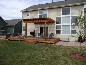 This is the back of a custom home with wood deck and pergola.